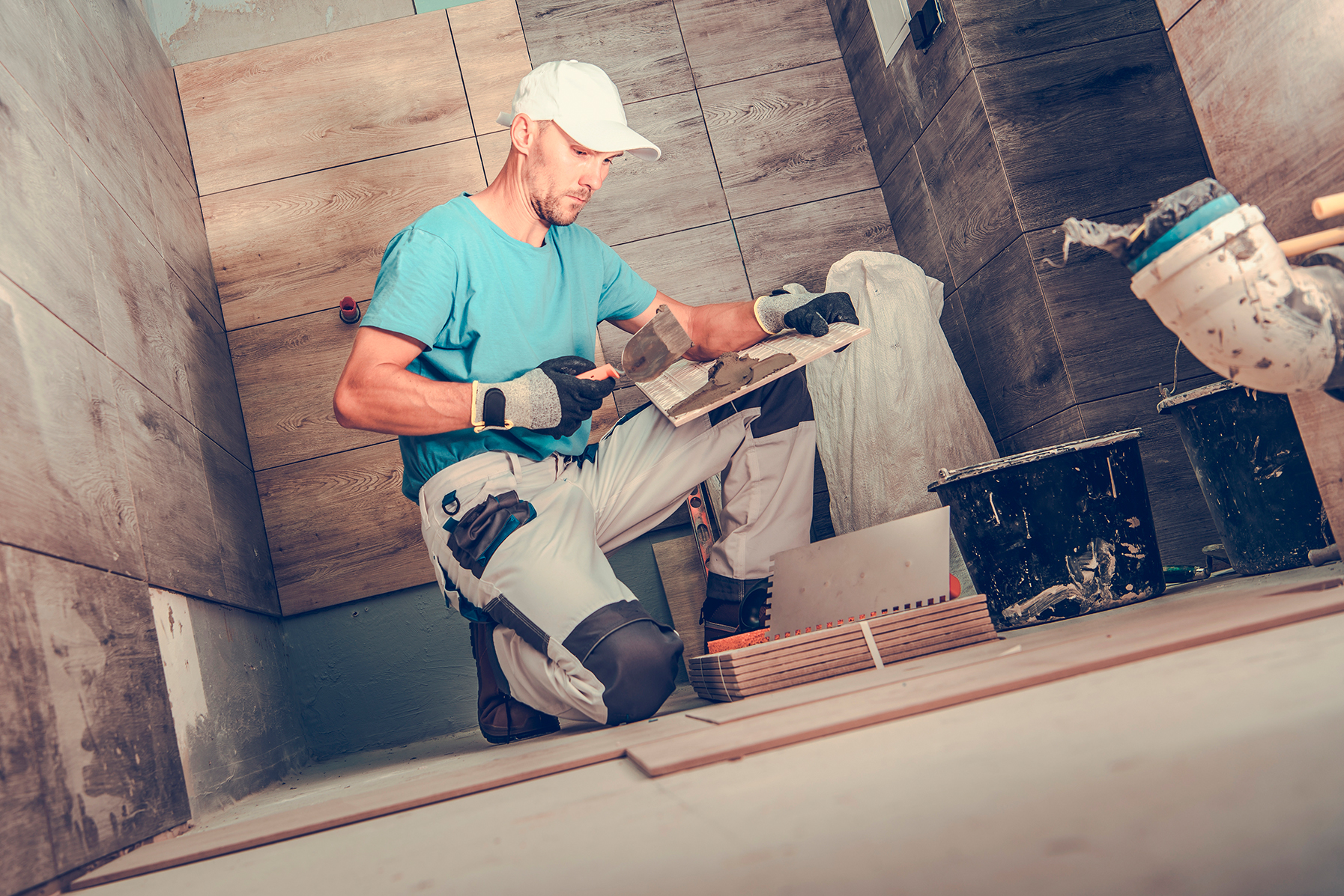 Professional architect in protective hardhat measuring wall with tape-line standing near step ladder construction safety and equipment during renovation process